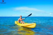 Man kayaking solo in a yellow kayak on the open sea.