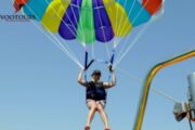 Person enjoying parasailing with a colorful parachute in Ras Al Khaimah