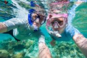 Couple taking a selfie underwater with snorkeling masks.