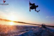 Wakeboarding at sunset with a high jump