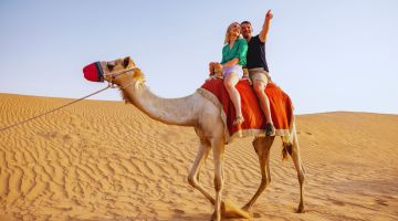 Child interacting with a camel during a desert safari experience