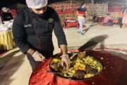 Chef serving a traditional BBQ platter at a desert camp.