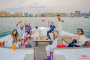 A group of smiling guests enjoying a luxury yacht tour in Dubai.