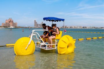 Group enjoying aqua cycling in Dubai with Atlantis in the background