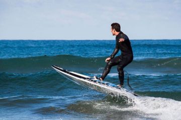 Man riding a jet board on ocean waves in Dubai.