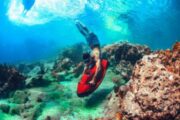 Underwater exploration with a red Seabob near coral reefs