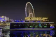 Luxury houseboat illuminated at night with Ain Dubai.