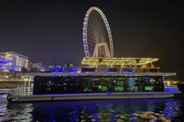 Luxury houseboat illuminated at night with Ain Dubai.