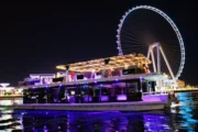 Illuminated houseboat with Ain Dubai in the background at night