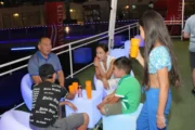 Family enjoying drinks on the deck of a houseboat at night