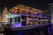 Modern houseboat with string lights at Dubai Marina at night