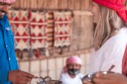 Group enjoying a meal and traditional storytelling in a Bedouin tent.