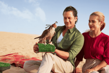 Couple interacting with a falcon during a desert safari