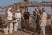 Guests learning about Bedouin culture at a traditional desert setting.