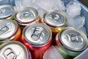 A collection of colorful soda cans chilling in ice.