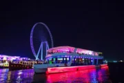 Dubai dinner cruise with vibrant lights and Ain Dubai in the background