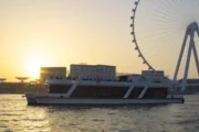 A luxury yacht cruising through Dubai Marina at sunset