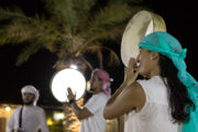 Woman playing a traditional drum under the night sky