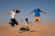 Family jumping in excitement in the desert.