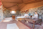 Traditional desert stone room interior with a couple enjoying morning coffee.