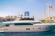 Luxury yacht sailing near Ain Dubai Ferris wheel.