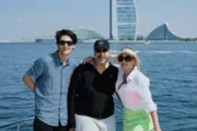 Group posing on a yacht with Burj Al Arab in the background