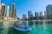 Group raising their hands in joy during a speedboat ride near Burj Al Arab