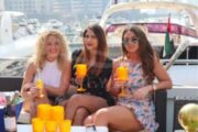 Three women relaxing with drinks on a yacht