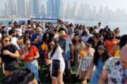 Crowd dancing and enjoying drinks on a yacht during the daytime