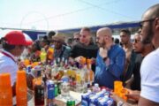 Guests selecting drinks from a bar on a yacht deck.