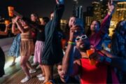 Group of people enjoying a yacht party with vibrant lighting.