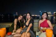 Three women smiling and posing during a yacht party