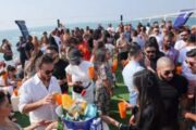 Guests enjoying beverages on the deck of a yacht with the sea as a backdrop.