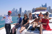 Guests enjoying a luxury yacht tour with a guide pointing out Dubai landmarks