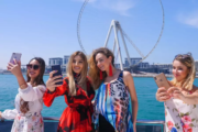 Group of women taking selfies with Ain Wheel in the background