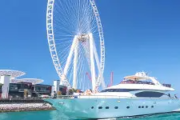 Luxury yacht cruising near Ain Dubai Ferris wheel in Dubai Marina