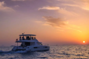 Luxury yacht silhouetted against a colorful Dubai sunset