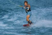 A young boy learning wakeboarding with determination in Dubai waters.