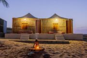 Desert camping tents with cozy interiors at night.