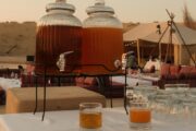 Two large glass dispensers with traditional Arabian drinks at a luxury desert camp.