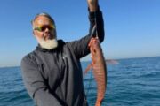 Angler holding a snapper caught during a fishing expedition