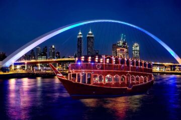 Al Faris luxury dhow cruise illuminated at night with neon signage.