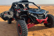 CAN-AM Maverick X3 parked on desert sand with doors open.