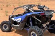 A Can-Am Maverick X3 dune buggy drifting in the desert.