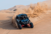 CAN-AM Maverick performing a high-speed drift on desert sand dunes