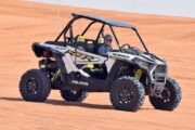 Polaris RZR 1000cc dune buggy driven across the desert dunes.