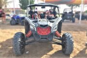 Family enjoying a desert dune buggy ride in a Can-Am Maverick.