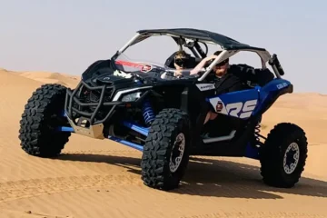 A Can-Am Maverick buggy racing across the desert.