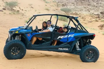 Polaris RZR XP 1000cc 4-seater dune buggy in the desert at sunset.