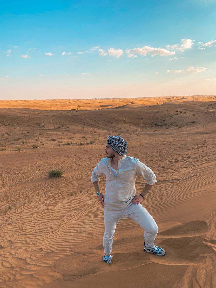 Traveler standing on desert dunes under a blue sky